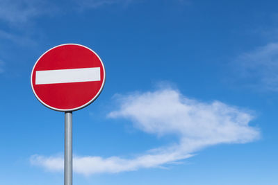 Low angle view of road sign against blue sky