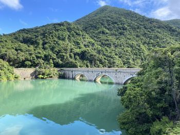 Arch bridge over river against sky