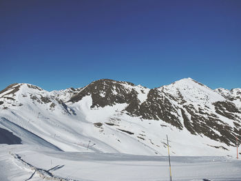 Scenic view of snowcapped mountains against clear blue sky