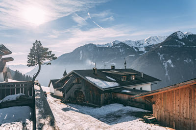 Houses by snowcapped mountains against sky