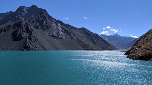 Scenic view of lake and mountains against blue sky