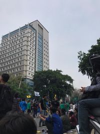 People on street against buildings in city