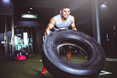 Man lifting tire in gym