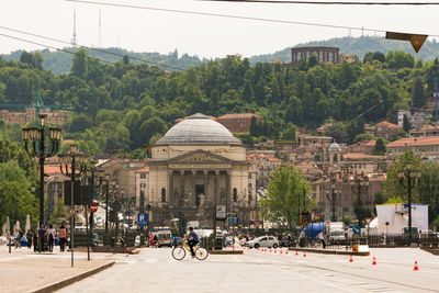 People on road by buildings in city