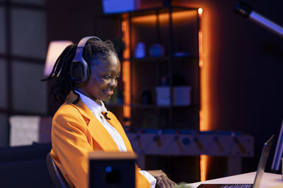 Side view of young woman using mobile phone