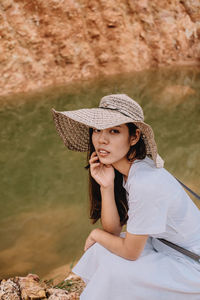 Young woman looking away while standing outdoors