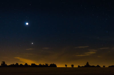 Scenic view of silhouette field against sky at night