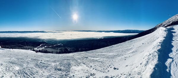 Scenic view of snowcapped mountains against blue sky