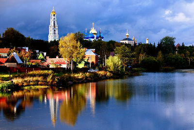 Scenic view of lake by buildings against sky