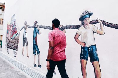 Rear view of people walking on wall