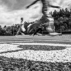 People playing soccer on field against sky