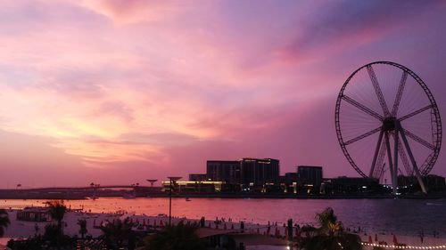 Ferris wheel in city at sunset