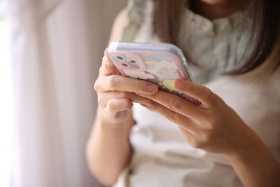 Midsection of woman using mobile phone