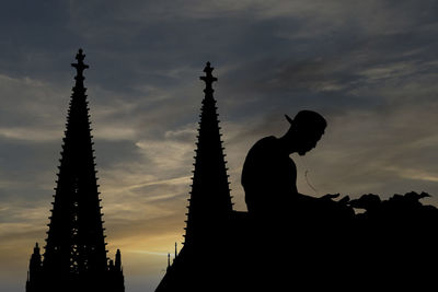 Silhouette woman standing against sky during sunset