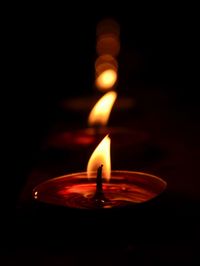 Close-up of illuminated light candle against black background