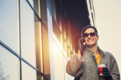 Portrait of smiling young woman using mobile phone