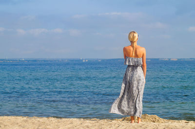 Rear view of woman standing on beach