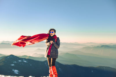 Woman standing on mountain against clear sky