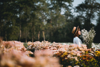 Side view of woman with pink flowers on trees