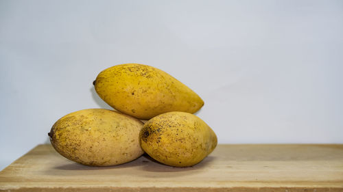 Close-up of fruits on table against white background