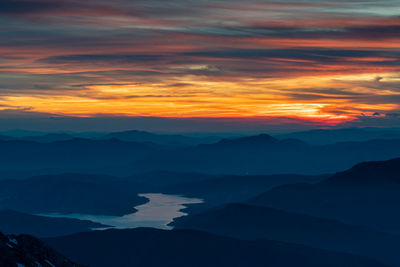 Fiery sky at sunset of the campotosto laka from the top of gran sasso of italy