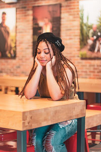 Portrait of a smiling young woman sitting on table