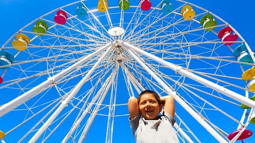 Low angle view portrait of ferris wheel against sky