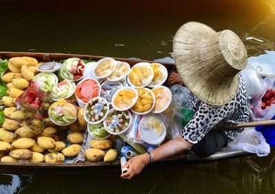 High angle view of woman selling food in boat on lake