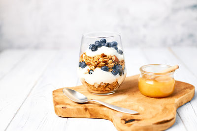 Healthy food concept. homemade granola with nuts and honey in a glass with yogurt and fresh berries 