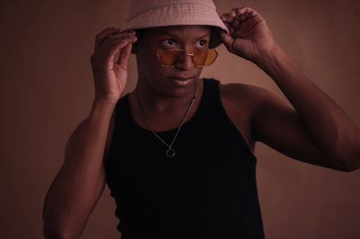 Young woman wearing hat against wall