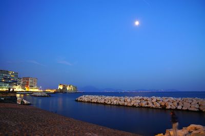 Castle by sea against sky at dusk