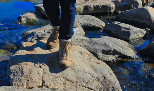 Low section of man standing on rock