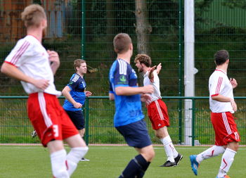Group of people playing soccer on field