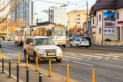 Vehicles on road by buildings in city