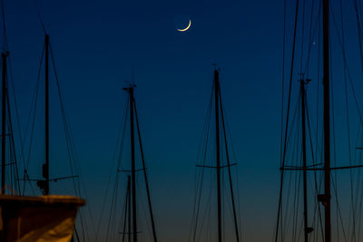 Low angle view of sailboats moored in sea against clear sky