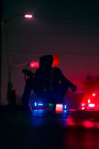 Man sitting on hoverboard at night