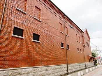 Brick wall against sky in city