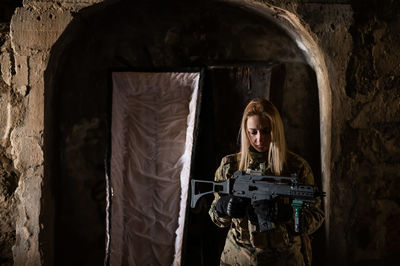 Rear view of young woman standing against wall