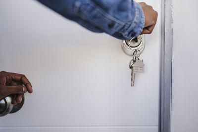 Hand of woman opening door with house keys