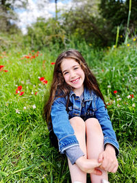 Portrait of young woman sitting on field