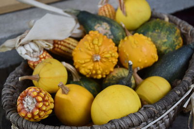 High angle view of decorated basket with pumpkins and corn