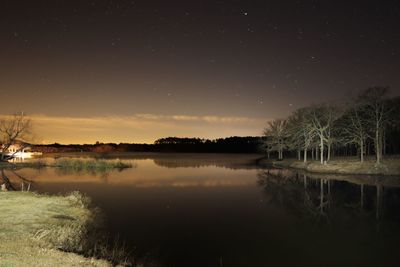 Scenic view of lake against sky at night