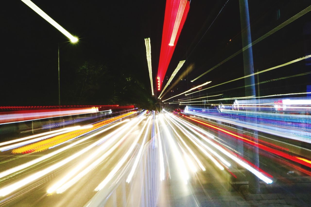 motion, light trail, illuminated, night, transportation, long exposure, speed, road, blurred motion, tail light, lighting equipment, street, street light, on the move, traffic, lit, rush hour, busy, glowing, outdoors, vehicle light, multi colored, city life, vibrant color