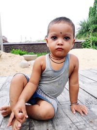 Portrait of cute boy sitting outdoors