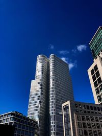 Low angle view of modern buildings against blue sky