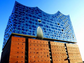 Low angle view of modern building against clear blue sky