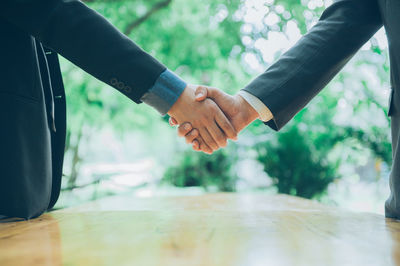 Midsection of couple holding hands