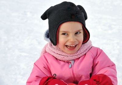 Girl in warm clothing on snow covered field