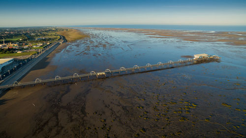 Aerial view of city by sea against sky