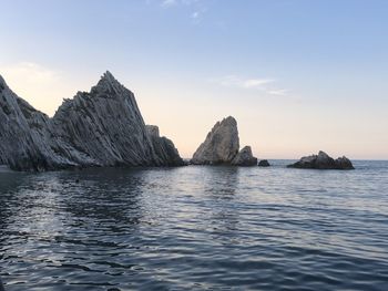 Scenic view of rocks in sea against sky